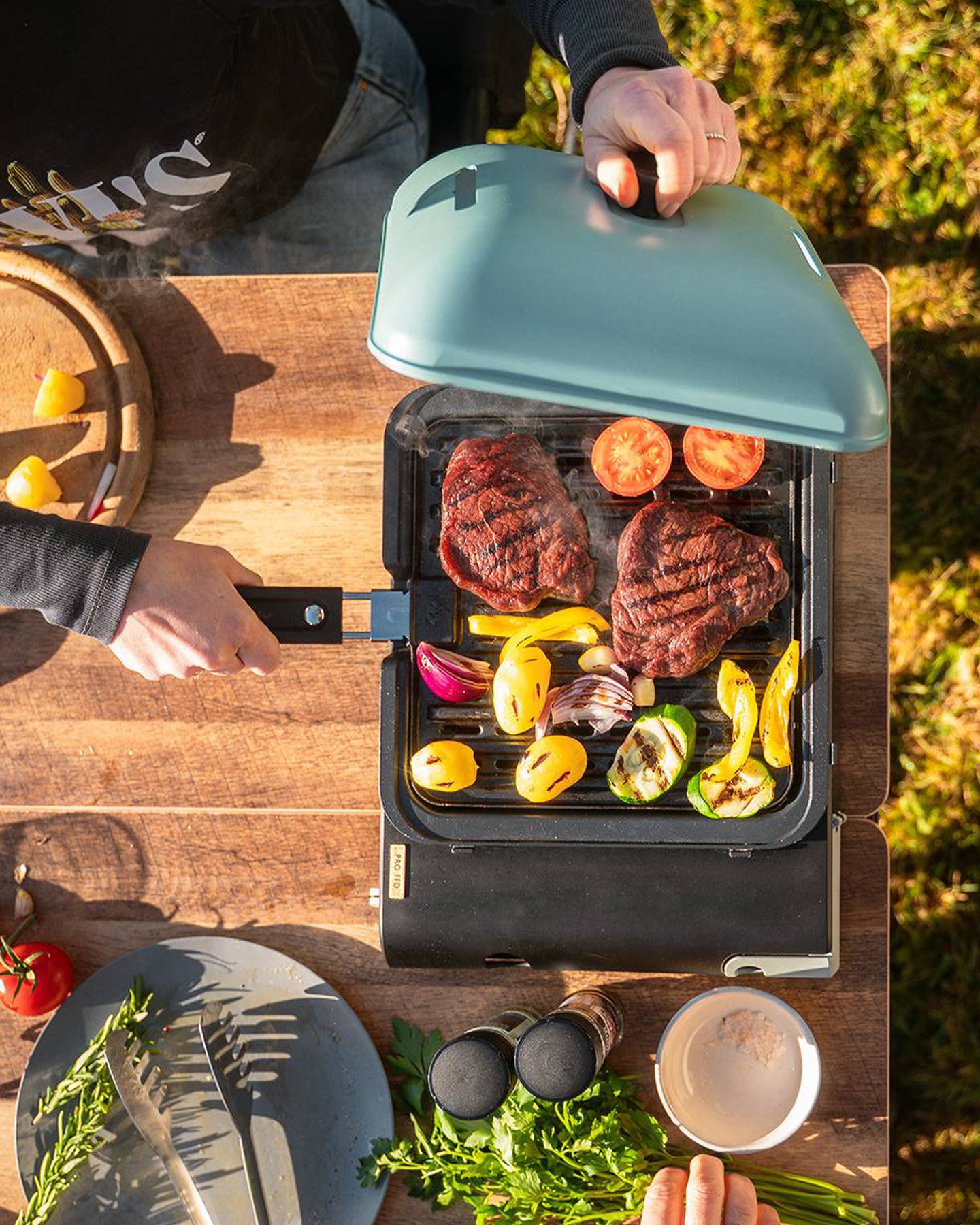 CADAC portabel gasgrill med kött och grönsaker under tillagning, kompakt campingkök för matlagning utomhus