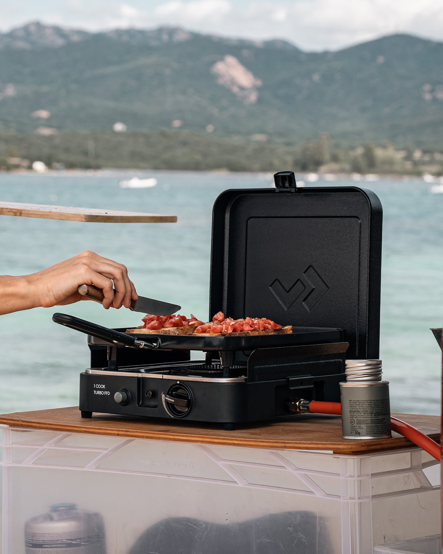 CADAC portable gas grill cooking steaks and vegetables outdoors, compact camping stove for outdoor cooking and food preparation