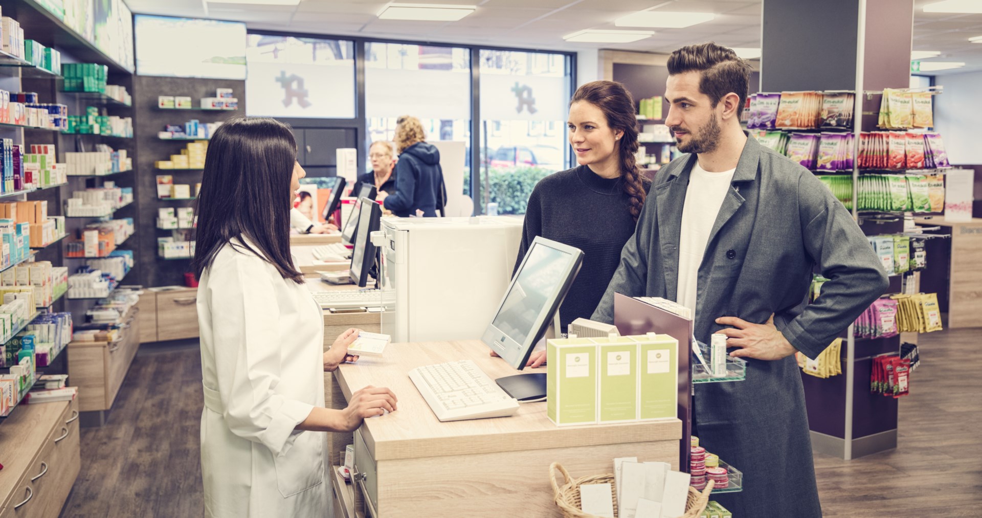 Man and woman talking to a pharmacist at the cashier